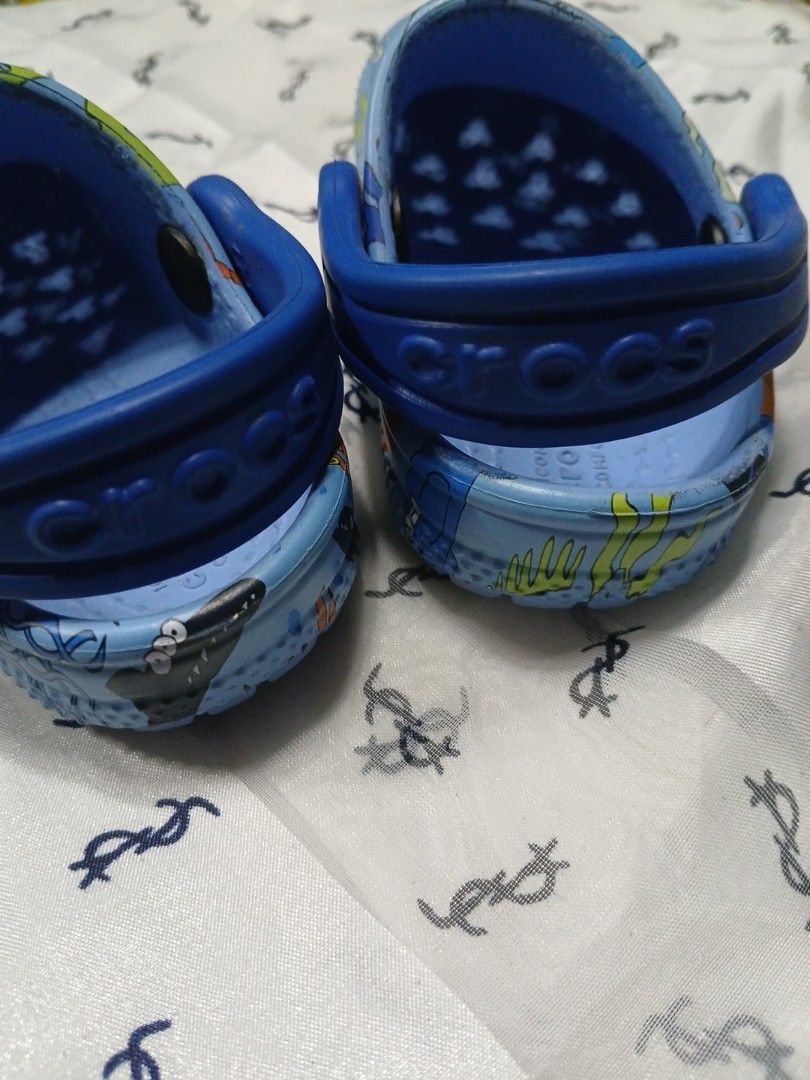 Crocs baby (Category: Babies & Kids Fashion) located in La Trinidad. Submitted by dashopperist (Listing ID 1461226667, Image 3). Description: - Blue Crocs clogs for kids - Fun ocean creature print (sharks, jellyfish, crabs) - Easy slip-on style - Heel strap for secure fit - Crocs logo and size 6 on sole - Ideal for playtime and beach days.