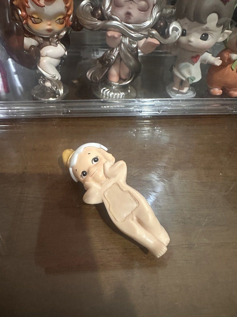 Cute Baby Figure with Gold Hat (Category: Designer & Blind Box Toys) located in Makati City. Submitted by msjlarsen (Listing ID 1461258710, Image 2). Description: - Adorable baby figure - Features a little gold hat - White collar detail - Figure is lying down, showcasing both back and front views - Ideal for collectors or as a charming display piece - No original box included.
