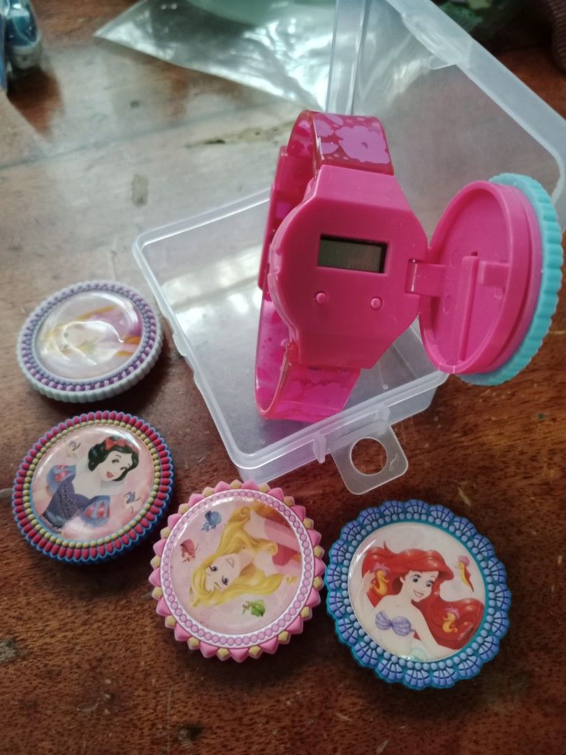 Disney Princess Watch with Interchangeable Bezels (Category: Women's Watches) located in Manila. Submitted by jamielleej87951 (Listing ID 1461224661, Image 3). Description: - Pink digital watch featuring beloved Disney Princesses. - Includes 4 interchangeable bezels: Cinderella, Rapunzel, Aurora, and Ariel. - Authentic item from Hong Kong Disneyland. - Features a clear digital watch face. - Adjustable watch band for a comfortable fit. - Comes wit