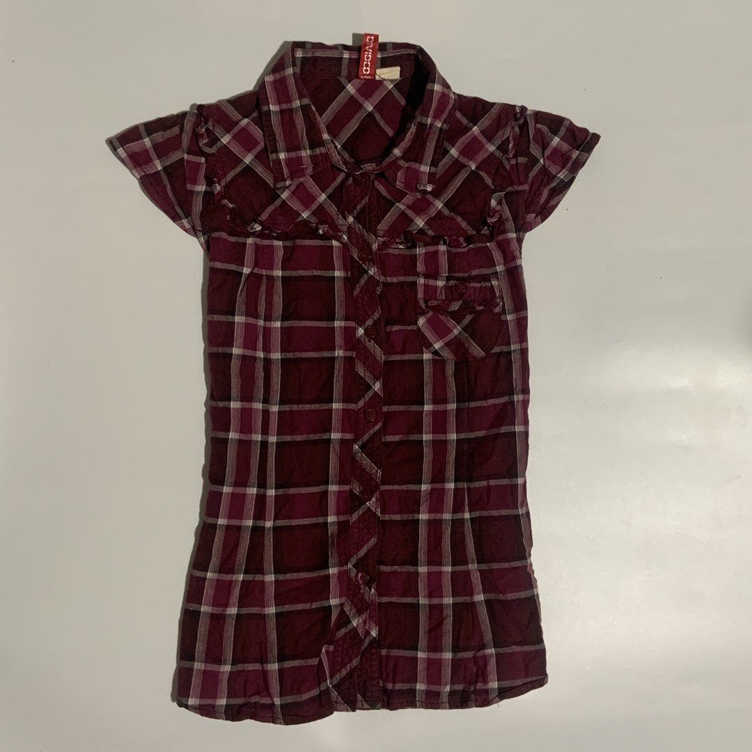 Divided Burgundy Plaid Button-Up Shirt (Category: Shirts) located in Carmen. Submitted by chillaxartfinds (Listing ID 1461264298, Image 1). Description: - Burgundy plaid short-sleeve shirt - Brand: Divided - Features ruffled trim on sleeves - Button-up front with a chest pocket - Estimated size: Small - Ideal for casual wear.