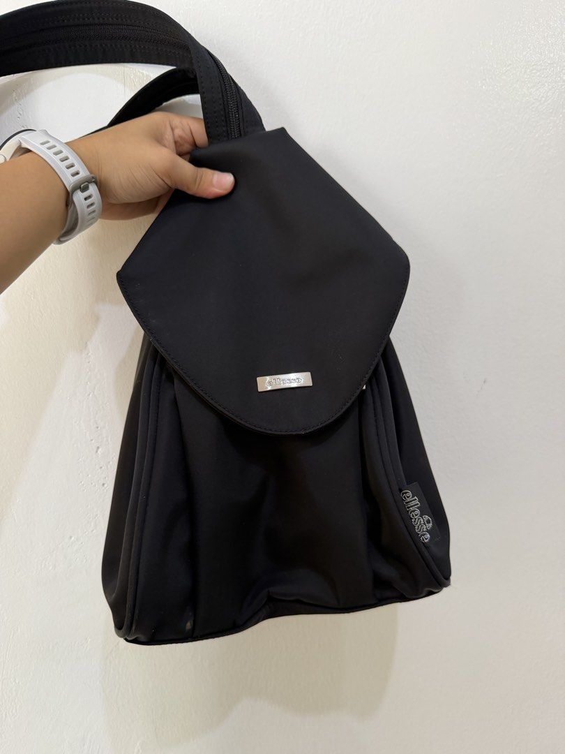 Ellesse Black Nylon Backpack Bag (Category: Backpacks) located in Manila. Submitted by escarchame98247 (Listing ID 1461143575, Image 1). Description: - Brand: Ellesse - Material: Black Nylon - Closure: Flap with magnetic snap - Main Compartment: Zippered - Straps: Adjustable - Style: Simple and functional - Ideal for: Everyday use.