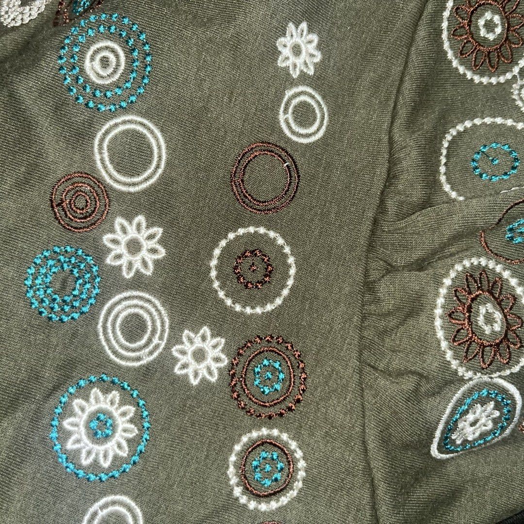 Embroidered Tank Top (Category: Sleeveless) located in Makati City. Submitted by midnightmelhem (Listing ID 1461133253, Image 2). Description: - Olive green tank top - Embroidered circular and floral patterns (white, brown, teal) - Spaghetti straps - Fabric has a slight sheen - Ideal for casual wear or layering.