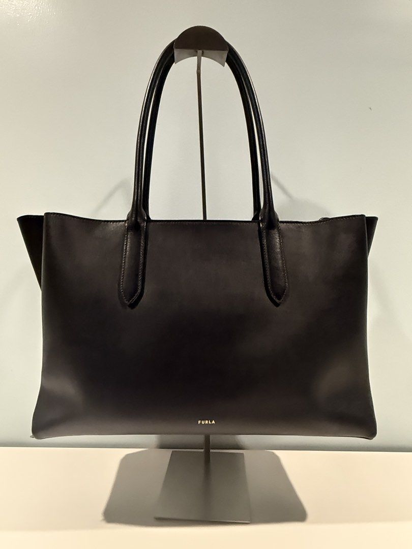 Furla Black Leather Tote Bag (Category: Luxury Bags & Wallets) located in Paranaque City. Submitted by miggyfeliciano (Listing ID 1461263041, Image 2). Description: Furla Leather Tote Bag - Original PRICE: ₱15,000 (Negotiable) MODEL: FURLA MERIDIANA TOTE - Handbag CONDITION: Used 2x only, good as new. Store bought last March 2026 BAG DETAILS: Outer material: Leather Lining: Polyurethane, polyamide Height: 10.0 “ Length: 15.5 “ Width: 5.0 “ Carryi