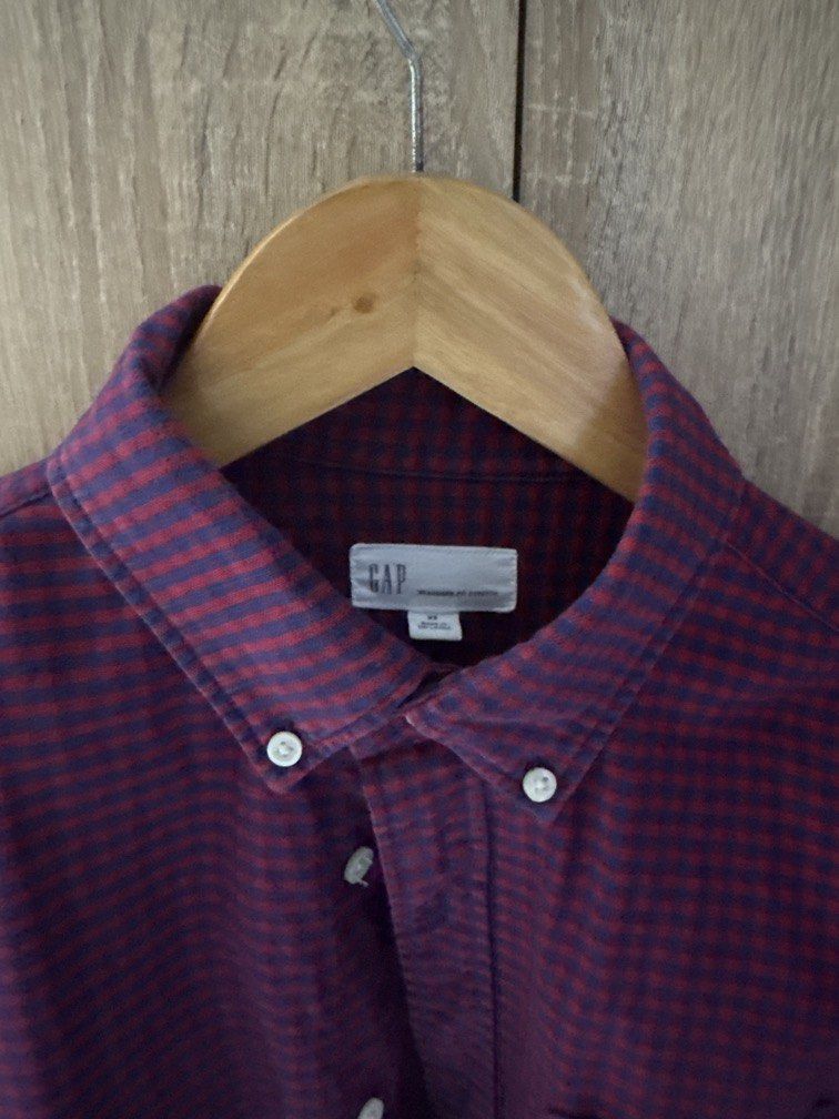 GAP Men's Red and Navy Gingham Button-Down Shirt (Category: Tshirts & Polo Shirts ) located in Mandaluyong City. Submitted by raykin (Listing ID 1461191415, Image 2). Description: - Classic red and navy gingham pattern - Brand: GAP - Style: Button-down collar - Features: Single chest pocket, long sleeves - Versatile: Ideal for casual or smart-casual outfits - Easy Pairing: Looks great with jeans or chinos.