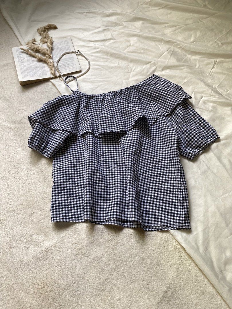 Gingham One Shoulder Ruffle Top Small-Med 37 (Category: Sleeveless) located in Poro. Submitted by joyceyuu (Listing ID 1461304879, Image 1). Description: - Cute one-shoulder gingham top - Features ruffles across the chest - Short sleeves - Lightweight and airy fabric - Perfect for casual outings or beach trips - Easy to pair with shorts or jeans.
