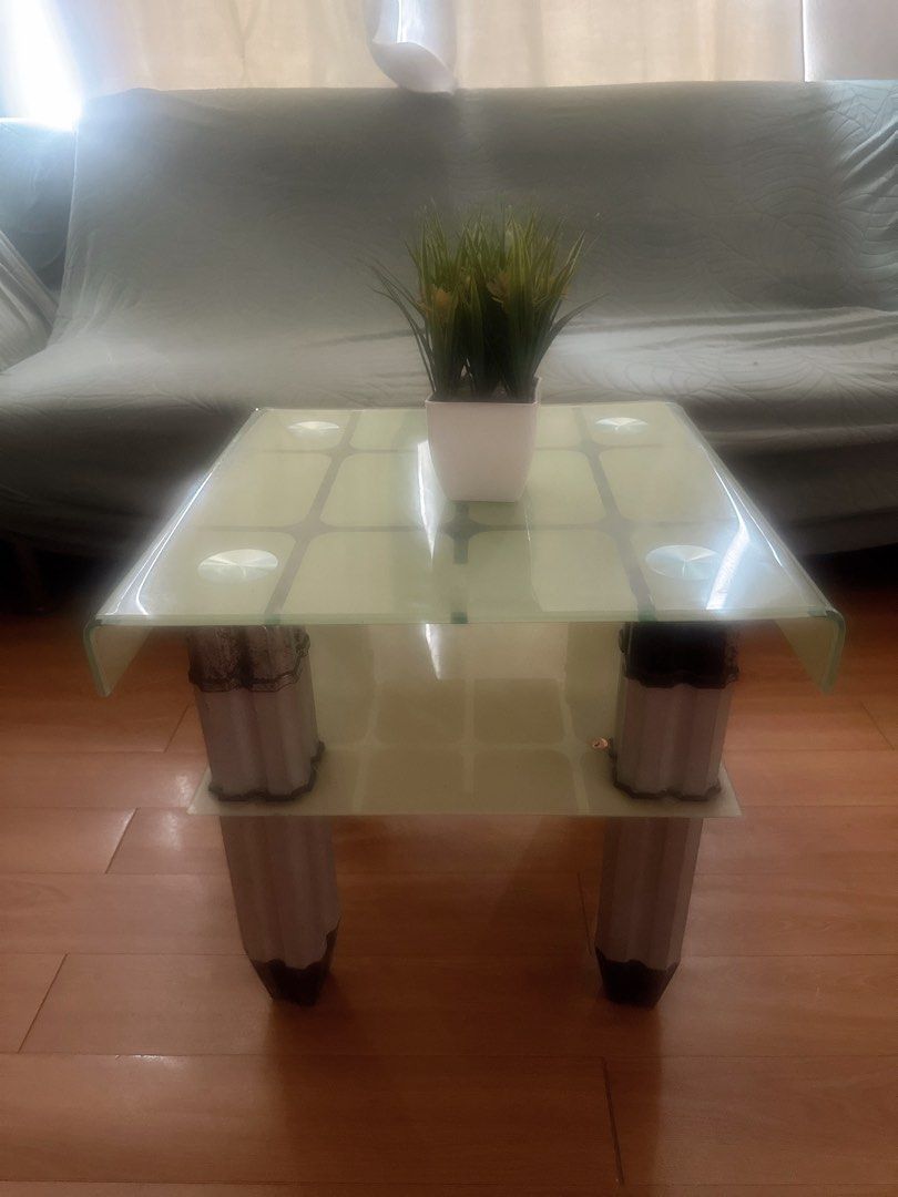 Glass Top Coffee Table with White Legs (Category: Tables & Sets) located in Manila. Submitted by dolcedeganda (Listing ID 1461208834, Image 1). Description: - Modern coffee table with a clear glass top. - Features a lower shelf for additional storage. - Stylish white legs with a decorative pattern. - Ideal for living rooms and lounges. - Easy to clean surface. - [Insert dimensions if known].