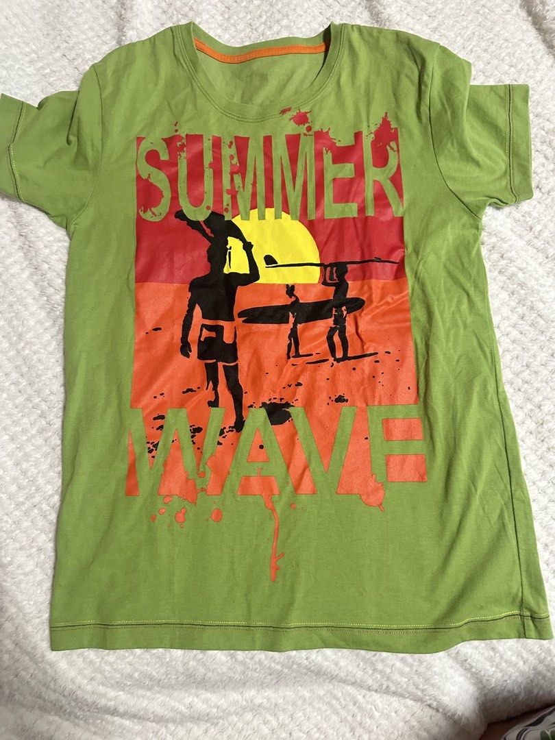 Green T-shirts with graphic prints bundle (Category: Shirts) located in Pasig City. Submitted by s4sayaki (Listing ID 1461174631, Image 1). Description: - Two green t-shirts for sale. - T-shirt 1: Features a 'Summer Wave' graphic with surfers and a sunset. - T-shirt 2: Features a koi fish graphic and 'shiratsuyu' text. - Both are short-sleeved. - Ideal for casual everyday wear..