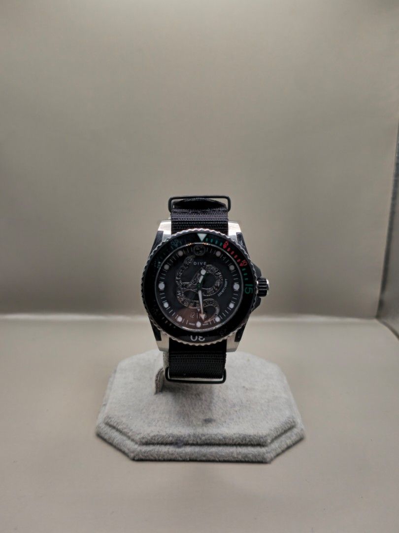 GUCCI Dive Watch Black Nylon Strap (Category: Luxury Watches) located in Manila. Submitted by secretwatch.mnl (Listing ID 1461311074, Image 2). Description: - Authentic Gucci Dive watch - Durable black nylon strap - Rotating bezel with signature green and red markers - Convenient date window on the dial - Water resistant for peace of mind - Ideal for both everyday wear and diving activities.