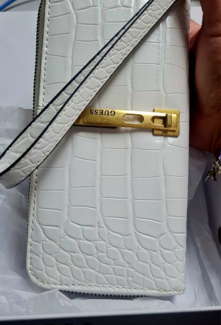 GUESS White Croc Embossed Wristlet Wallet (Category: Wallets & Card holders) located in Manila. Submitted by jazgotlucky (Listing ID 1461255306, Image 3). Description: - GUESS white croc embossed wristlet wallet - Comes with original box and tags - Multiple card slots and compartments for organization - Elegant gold hardware detail on the front - Detachable wrist strap for convenience - never been used, decluttering.