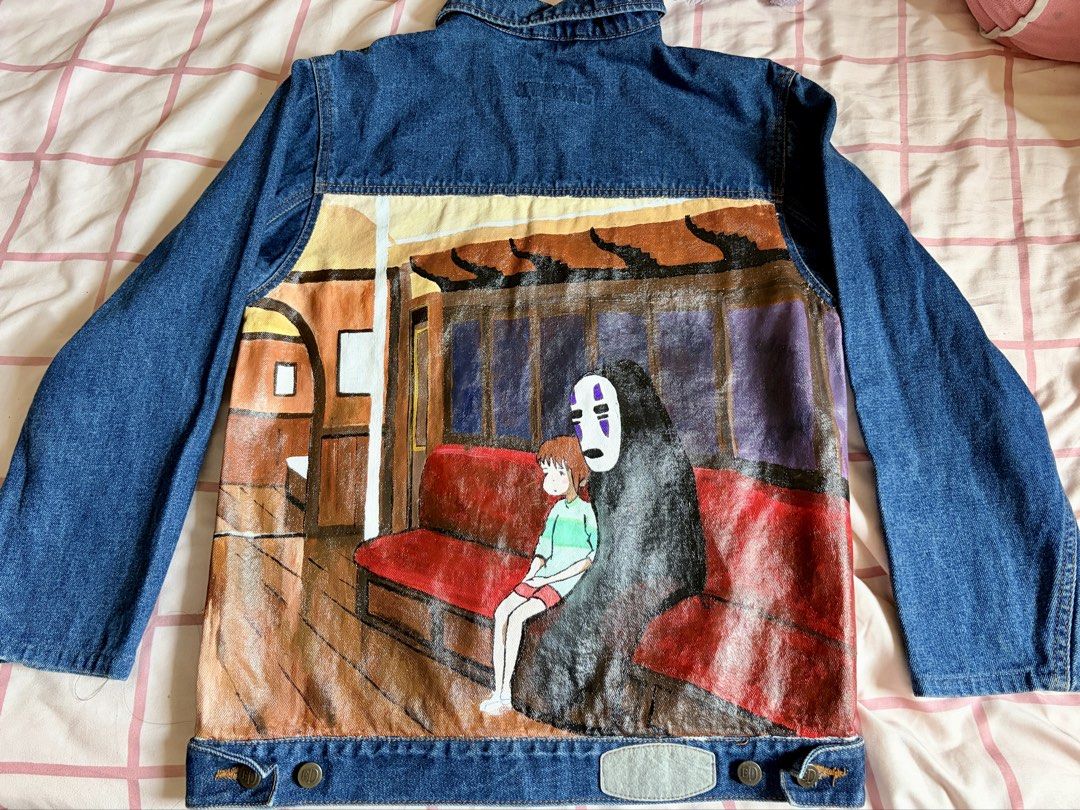 Hand-Painted Studio Ghibli Spirited Away Denim Jacket (Category: Coats, Jackets and Outerwear) located in Manila. Submitted by popofcolor.ph (Listing ID 1461299151, Image 1). Description: - Custom hand-painted denim jacket - Features Spirited Away scene with Chihiro and No-Face on the train - Unique, one-of-a-kind anime fan item - Vibrant and detailed artwork - Perfect for personal style and collectors.
