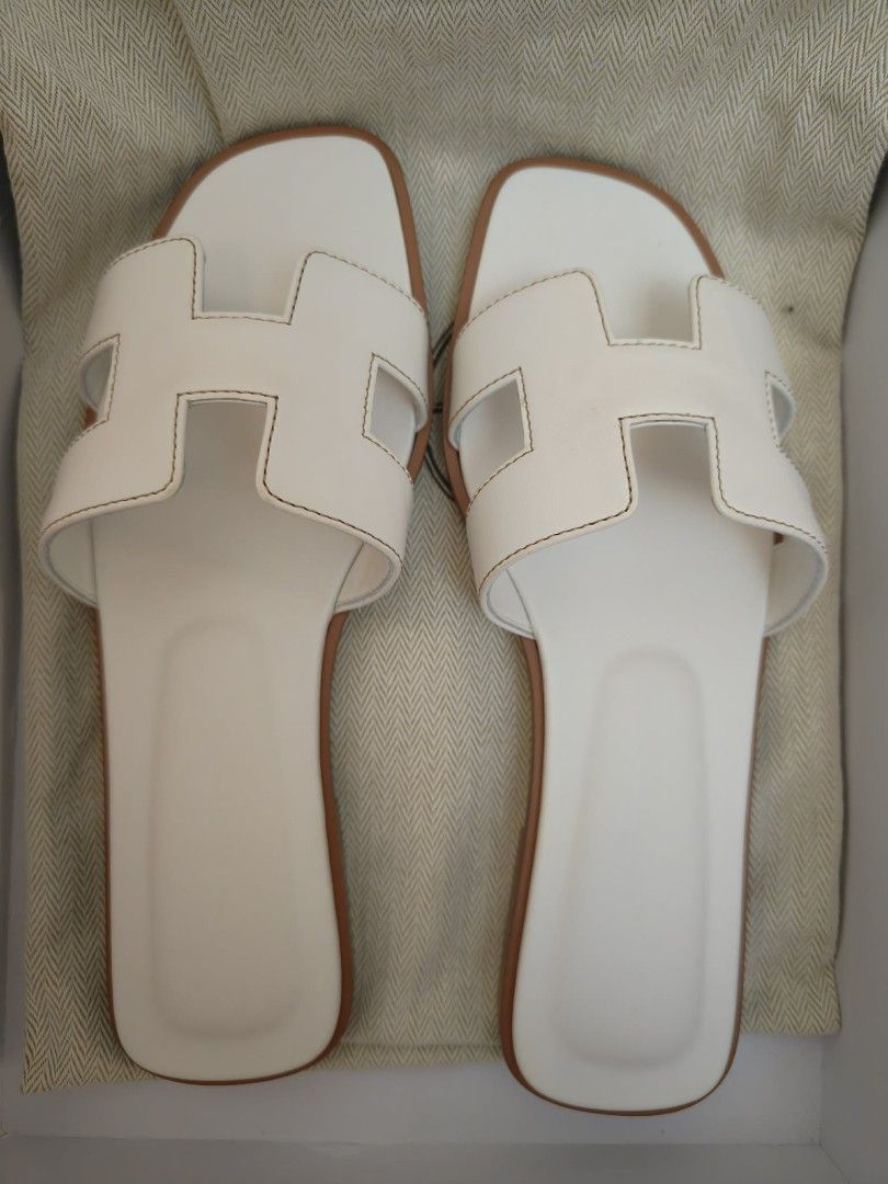 Hermès Blanc Oran Sandal (Category: Flats & Sandals) located in Quezon City. Submitted by mmmm2000 (Listing ID 1461311510, Image 1). Description: These are a pair of white leather Hermès Oran sandals featuring the iconic cut-out "H" strap design..