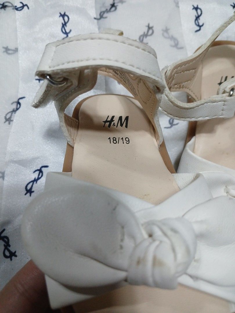 H&M baby sandals (Category: Babies & Kids Fashion) located in La Trinidad. Submitted by dashopperist (Listing ID 1461225938, Image 2). Description: - Cute white sandals from H&M - Features a sweet bow on the front strap - Adjustable ankle strap for a secure fit - Perfect for little ones - Size 18/19.