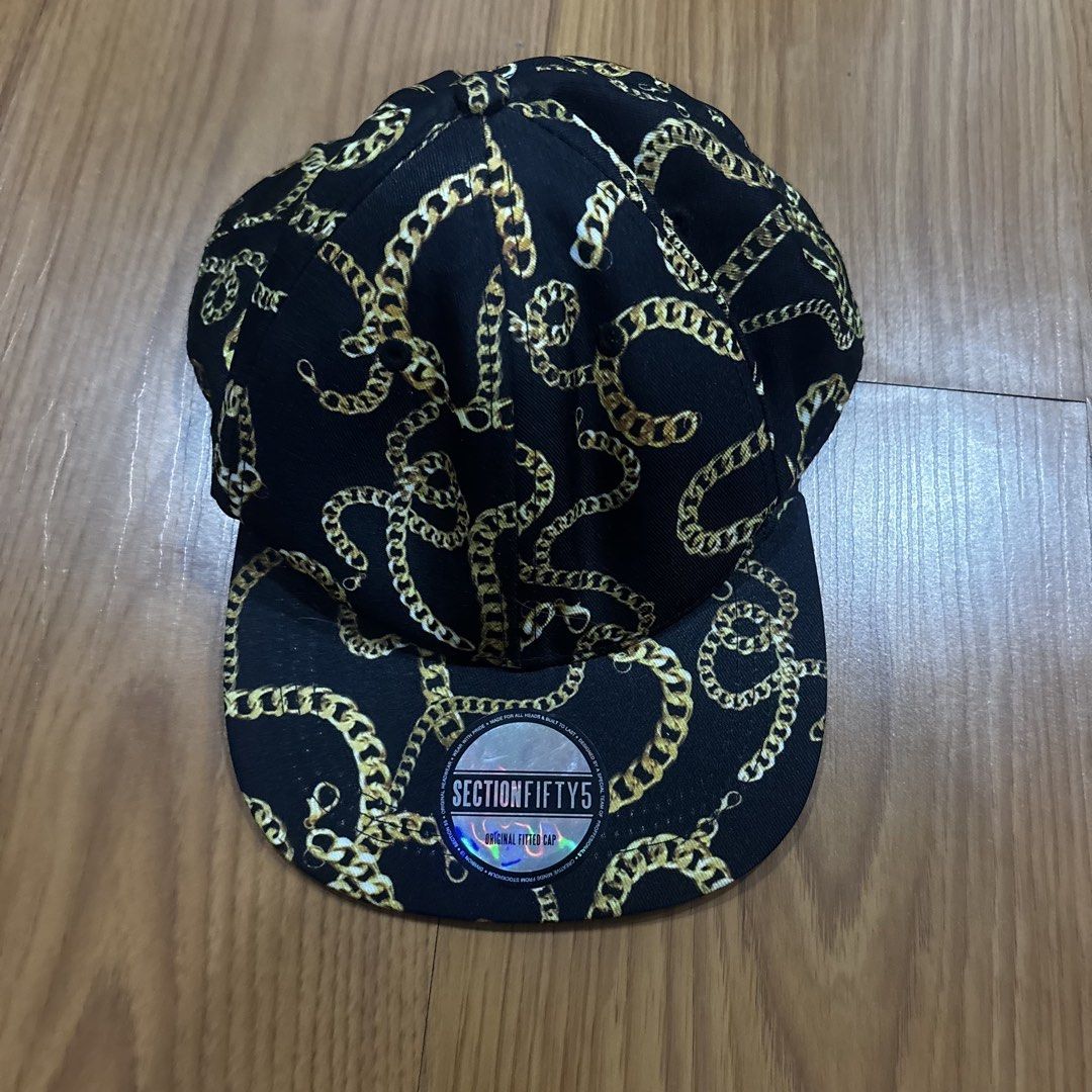 H&M Divided Black Gold Chain Print Snapback Cap (Category: Caps & Hats) located in Quezon City. Submitted by murafindsph (Listing ID 1461299454, Image 1). Description: - Brand: H&M Divided - Type: Snapback Cap - Color: Black - Design: All-over gold chain print - Size: One size fits most - Style: Adds flair to any outfit.