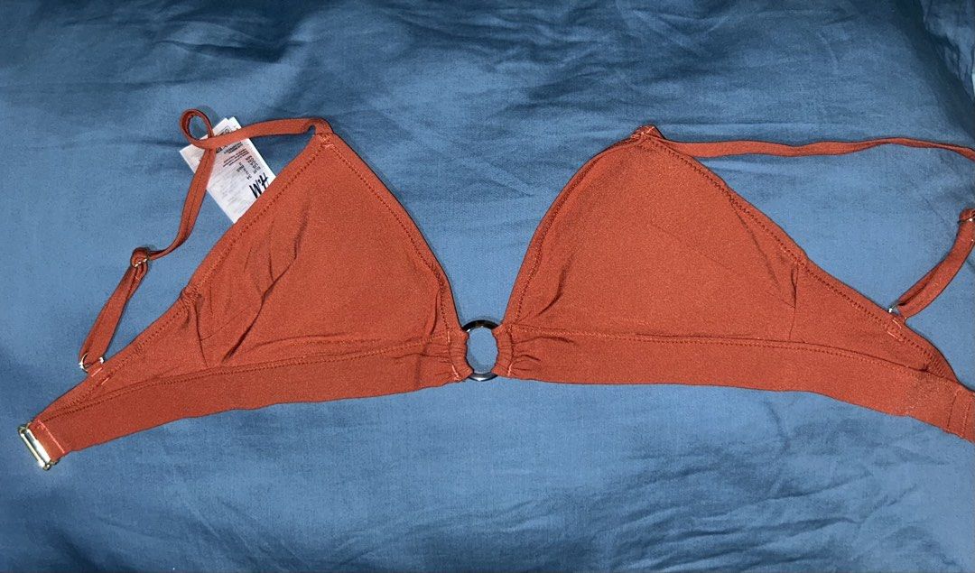 H&M Rust Orange Ring Detail Triangle Bikini Top (Category: Bikinis & Swimsuits) located in Palo. Submitted by kaleidoscope_676 (Listing ID 1461123547, Image 1). Description: - Brand: H&M - Color: Rust Orange - Features: Center ring detail, adjustable straps, clasp back closure - Condition: Brand new with tags attached - Ideal for: Beach trips, pool days.