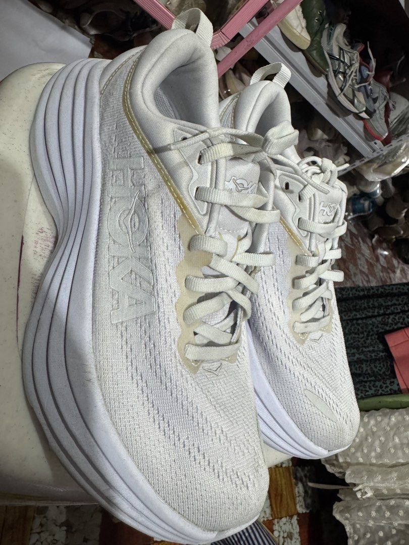 Hoka One (Category: Sneakers & Footwear) located in Manila. Submitted by wildbear.e10374 (Listing ID 1461196174, Image 1). Description: - White Hoka running shoes - Versatile: suitable for running or everyday wear - Comfortable fit - Soles show minor dirt from use - White laces - Hoka logo featured on the side and sole.