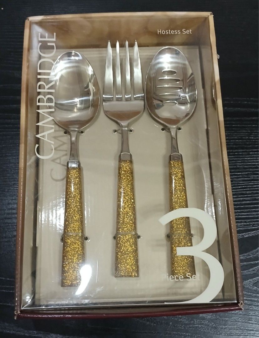 Hostess Set (Category: Other Kitchenware & Tableware) located in Davao. Submitted by ferdipt (Listing ID 1461126300, Image 1). Description: A Cambridge Hostess Set featuring three stainless-steel utensils with gold glitter-filled acrylic handles. This 3-piece hostess set includes a serving spoon, a serving fork, and a smaller spoon, all presented in a branded box. The handles have a textured, sparkling gold glitter design encased in clear acrylic
