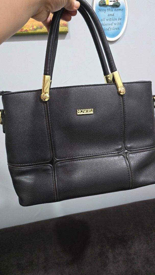 HOWRU Black Leather Handbag with Gold Hardware (Category: Luxury Bags & Wallets) located in Taguig. Submitted by threadsntable (Listing ID 1461278602, Image 1). Description: - Brand: HOWRU - Material: Black Leather - Hardware: Gold details on handles and logo plate - Design: Structured with paneling - Handles: Double for comfortable carrying - Versatile: Ideal for everyday use or evening events.
