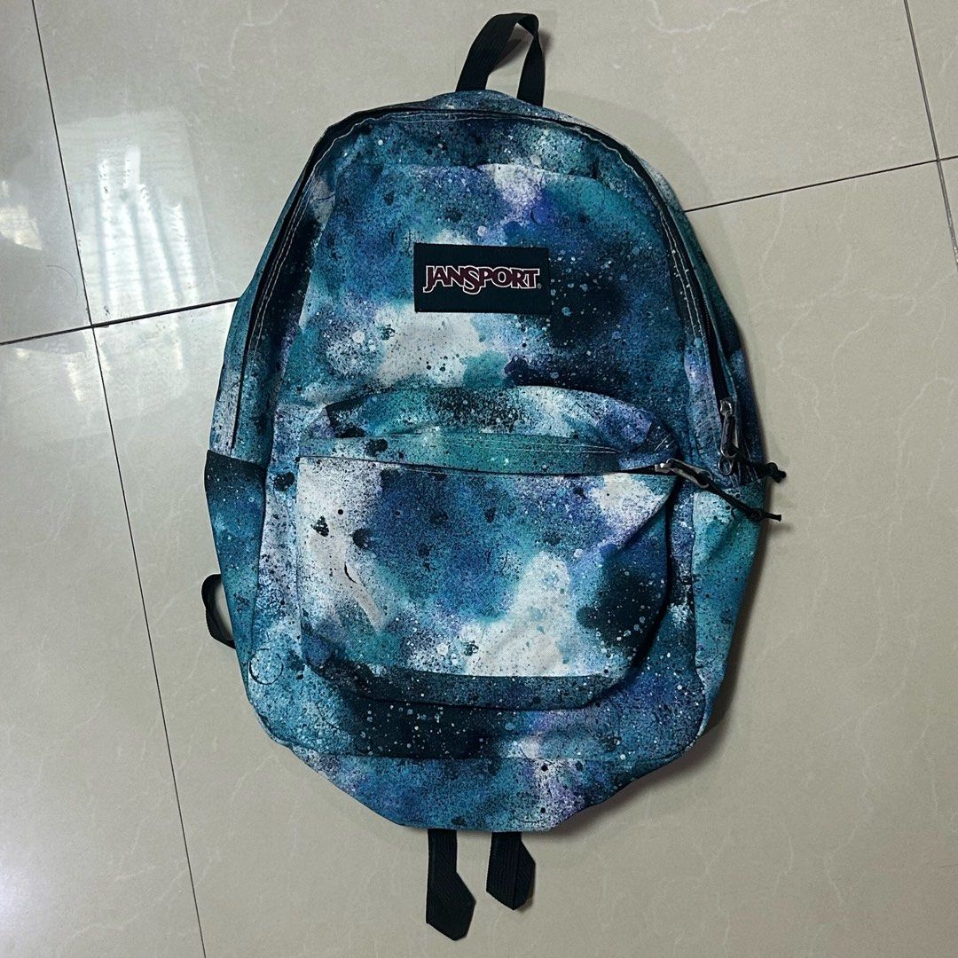 Jansport Backpack - Galaxy/Space Print (Category: Backpacks) located in Quezon City. Submitted by stlntno095 (Listing ID 1461144857, Image 1). Description: - Jansport backpack with a galaxy/space print - Features blue and white splatter designs - Includes a main compartment and a front pocket - Adjustable straps for a comfortable fit - Perfect for school or everyday use - Has minor defect (yellowish inner lining).