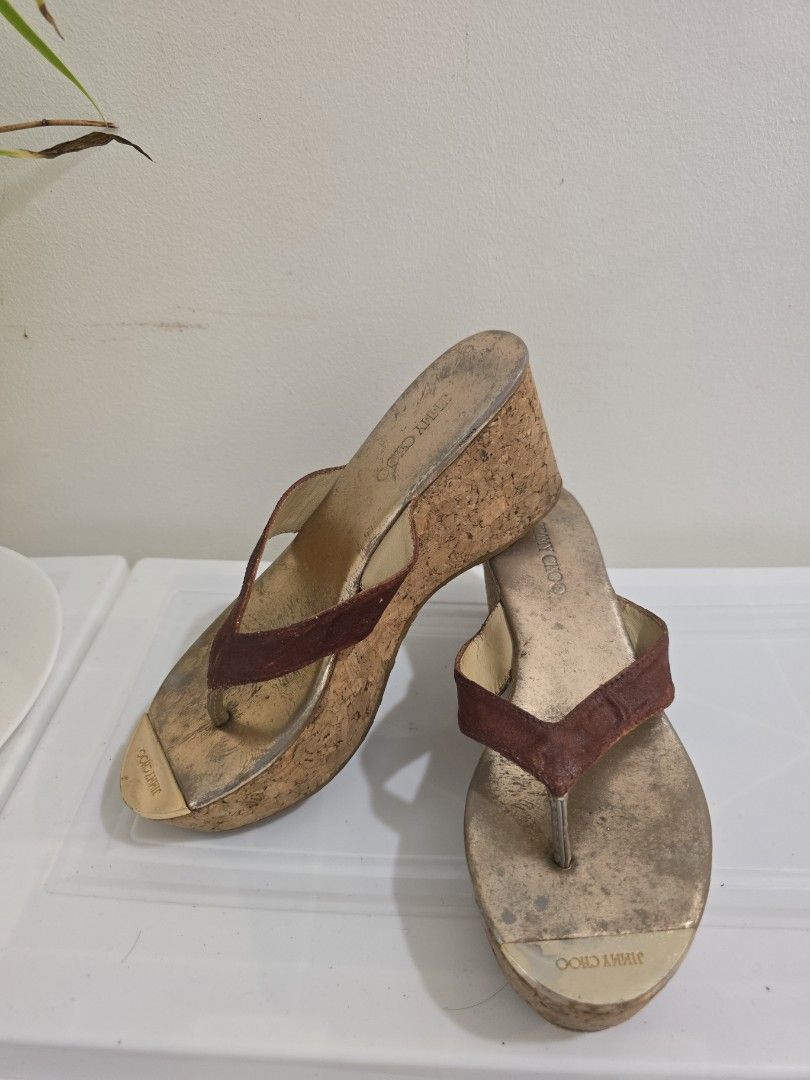 Jimmy Choo Cork Wedge Thong Sandals (Category: Wedges) located in Cavite. Submitted by mama_decluterring (Listing ID 1461131793, Image 1). Description: - Brand: Jimmy Choo - Style: Thong wedge sandals - Wedge: Cork - Footbed: Metallic gold - Straps: Brown suede - Versatile: Great for dressing up or down - Condition: Some signs of wear on footbed and sole.