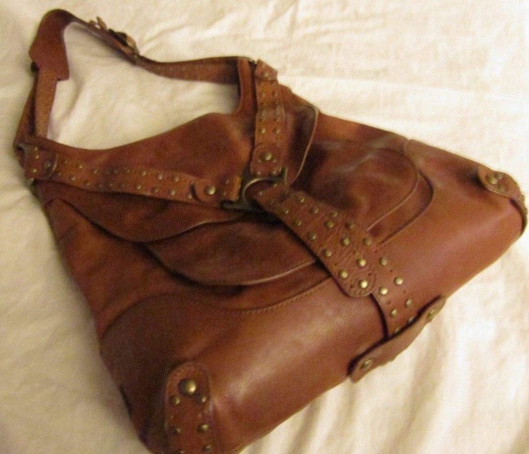 Kooba USA leather brown studs bag (Category: Shoulder Bags) located in Marikina City. Submitted by minimalistmanila (Listing ID 1461132198, Image 2). Description: Genuine Kooba caramel brown shoulder bag purchased in Florida USA. Size is M/L. Heavy duty as made from real leather with metal studs. Funky style. Invest in a good heavy duty bag now. -Needs cleaning as kept in storage. Get this now!.