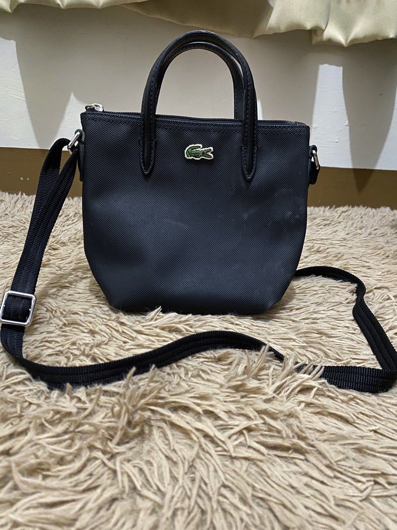 Lacoste Mini L 12.12 Concept Tote Bag (Category: Luxury Bags & Wallets) located in Lucena. Submitted by catherineluces18 (Listing ID 1461282781, Image 1). Description: 8"inch (width) 6.5"inch (length) highlights: •color black •top handle •adjustable shoulder strap • textured finish • no flaws • need wash only • main compartment.