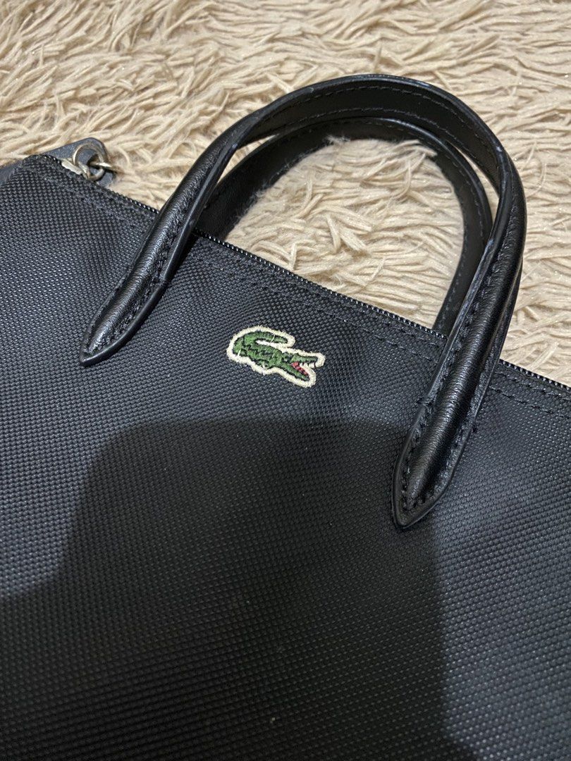 Lacoste Mini L 12.12 Concept Tote Bag (Category: Luxury Bags & Wallets) located in Lucena. Submitted by catherineluces18 (Listing ID 1461282781, Image 2). Description: 8"inch (width) 6.5"inch (length) highlights: •color black •top handle •adjustable shoulder strap • textured finish • no flaws • need wash only • main compartment.