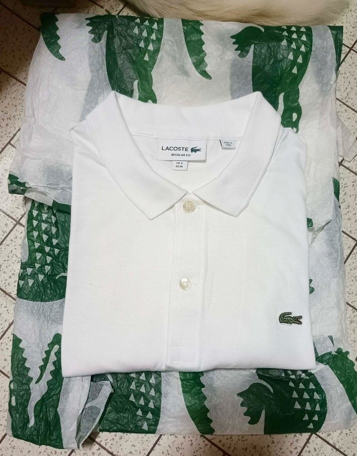 Lacoste Regular Fit White Polo Shirt (Category: Tshirts & Polo Shirts ) located in Makati City. Submitted by elgamapenumbra (Listing ID 1461179958, Image 1). Description: - White Lacoste Polo Shirt - Size: US Medium / French 4 - Fit: Regular - Origin: Made in Peru - Features: Iconic crocodile logo - Style: Versatile for casual or smart-casual wear.