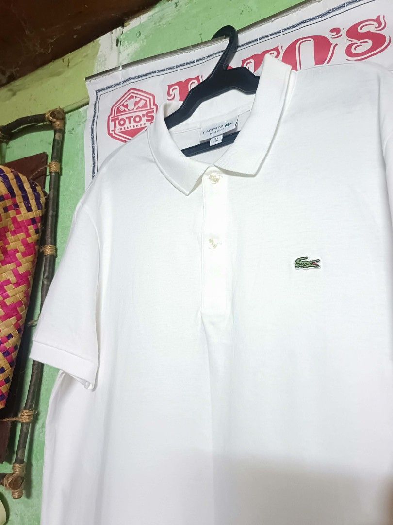 Lacoste Regular Fit White Polo Shirt (Category: Tshirts & Polo Shirts ) located in Makati City. Submitted by elgamapenumbra (Listing ID 1461179958, Image 2). Description: - White Lacoste Polo Shirt - Size: US Medium / French 4 - Fit: Regular - Origin: Made in Peru - Features: Iconic crocodile logo - Style: Versatile for casual or smart-casual wear.