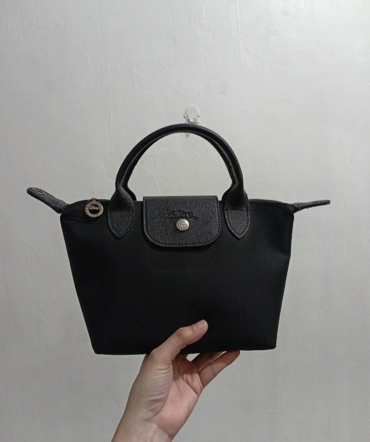 Le Pliage Neo XS Top Handle Bag (Category: Luxury Bags & Wallets) located in Manila. Submitted by eriiicaspage (Listing ID 1461269922, Image 2). Description: PreOwned Lighlt Used le Pliage Neo XS top handle bag black Thick nylon Material - Spacious interior with zipper closure and snap button flap No jellytag inside Min Rubs ,Air bubbles at the bottom of the bag Good Condition 8.9/10 .