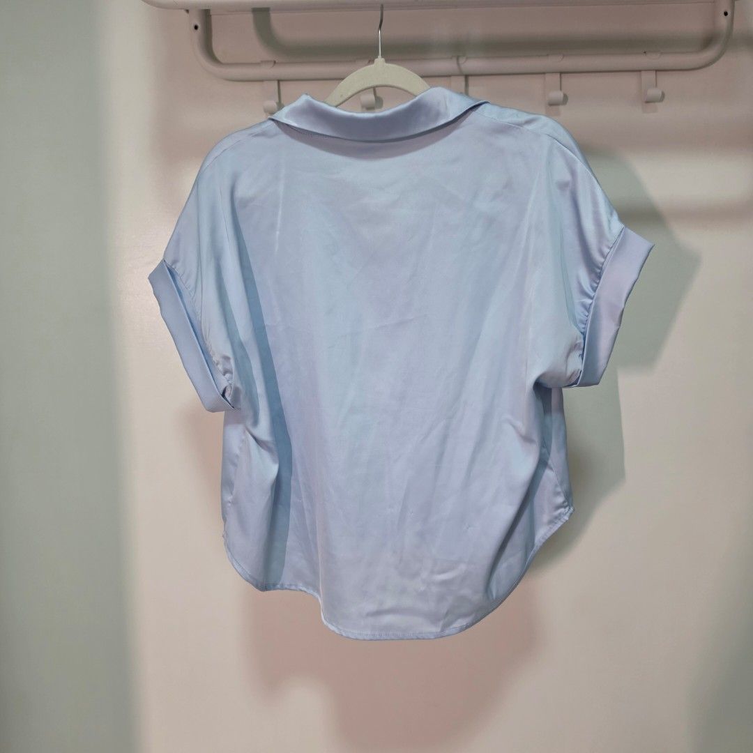 Light Blue Short Sleeve Button Up Shirt (Category: Tshirts & Polo Shirts ) located in Mandaluyong City. Submitted by Llyssa12 (Listing ID 1461268608, Image 3). Description: - Light blue short sleeve shirt - Button-up front - Collar detail - Silky material - Versatile for casual or dressed-up looks - Easy to style - Fits Medium Size - Only used twice for office wear -Shipping is shouldered by the buyer.