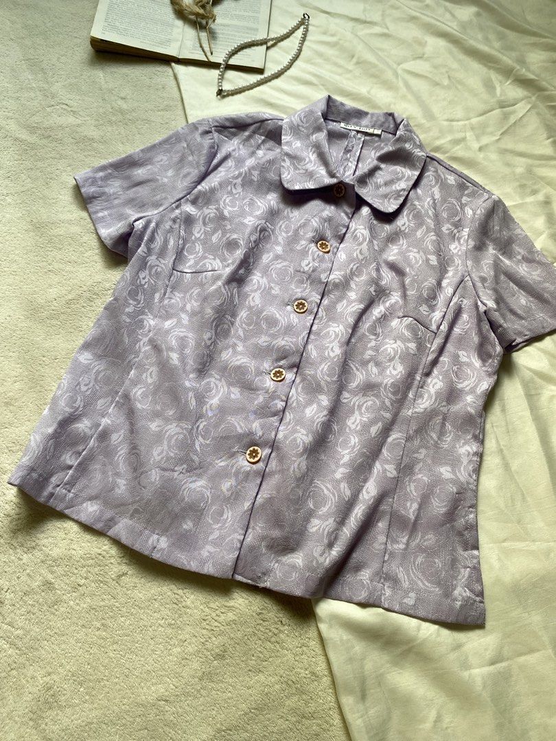 Lilac Floral Pattern Short Sleeve Button-Up Blouse Small-Med 37 (Category: Blouses) located in Poro. Submitted by joyceyuu (Listing ID 1461304092, Image 2). Description: - Light purple blouse - Subtle floral pattern - Short sleeves - Classic collar - Button-up front - Ideal for spring/summer outfits - Can be dressed up or down.