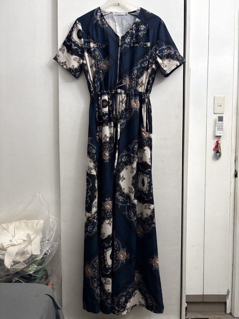 Lorraine Navy Blue Patterned Maxi Dress Size 10 (Category: Dresses) located in Quezon City. Submitted by thebutingthings (Listing ID 1461267443, Image 1). Description: - Navy blue maxi dress - Cool patterned print - Short sleeves - Drawstring waist for a flattering fit - Zip-up front closure - Convenient side pockets - Versatile for casual outings or dressing up.