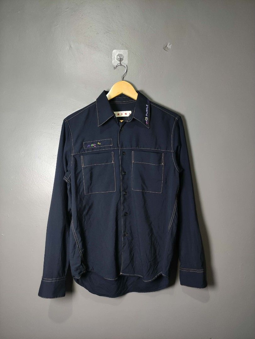 Marni Navy Blue Shirt with Contrast Stitching (Category: Luxury Apparel) located in Batangas. Submitted by andifits.ph (Listing ID 1461294949, Image 1). Description: - Navy blue Marni shirt -Size 38 -"Width 20" Lenght 27" No issue - Features contrast stitching throughout - Two chest pockets with button closures - Button-up front - Embroidered details on collar and chest pocket - Long sleeves with button cuffs - Ideal for casual or smart-casual ou