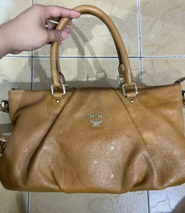 MCM Monogram Leather Tote Bag (Category: Luxury Bags & Wallets) located in Manila. Submitted by boldfire_315559 (Listing ID 1461234422, Image 1). Description: - Brown MCM tote bag - All-over monogram print - Genuine leather material - Features two top handles - Perfect for everyday use.