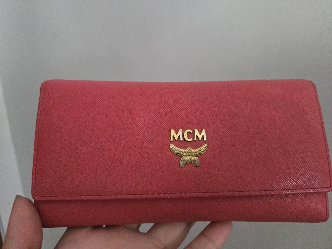 MCM Pink Leather Long Wallet (Category: Luxury Bags & Wallets) located in Rizal. Submitted by nads_a_m (Listing ID 1461147170, Image 1). Description: - Pink MCM long wallet - Durable saffiano leather exterior - Signature gold MCM logo hardware - Striking bright orange interior - Numerous card slots for organization - Spacious compartment for cash - Classic and functional design.