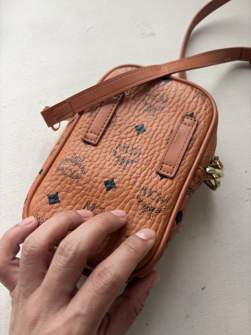 MCM Vertical Mini Crossbody Bag in Cognac (Category: Sling Bags) located in Mandaluyong City. Submitted by material_boi (Listing ID 1461161859, Image 3). Description: Used once then stored. Perfect pang-strolling lang sa mall or you don’t like carrying big bags. In iconic cognac color. Gold na gold pa hardwares nyan. Smooth zippers. With lining inside. Detachable and adjustable strap. Approx 7 inches long and 4.5 inches wide. Structured bag so it