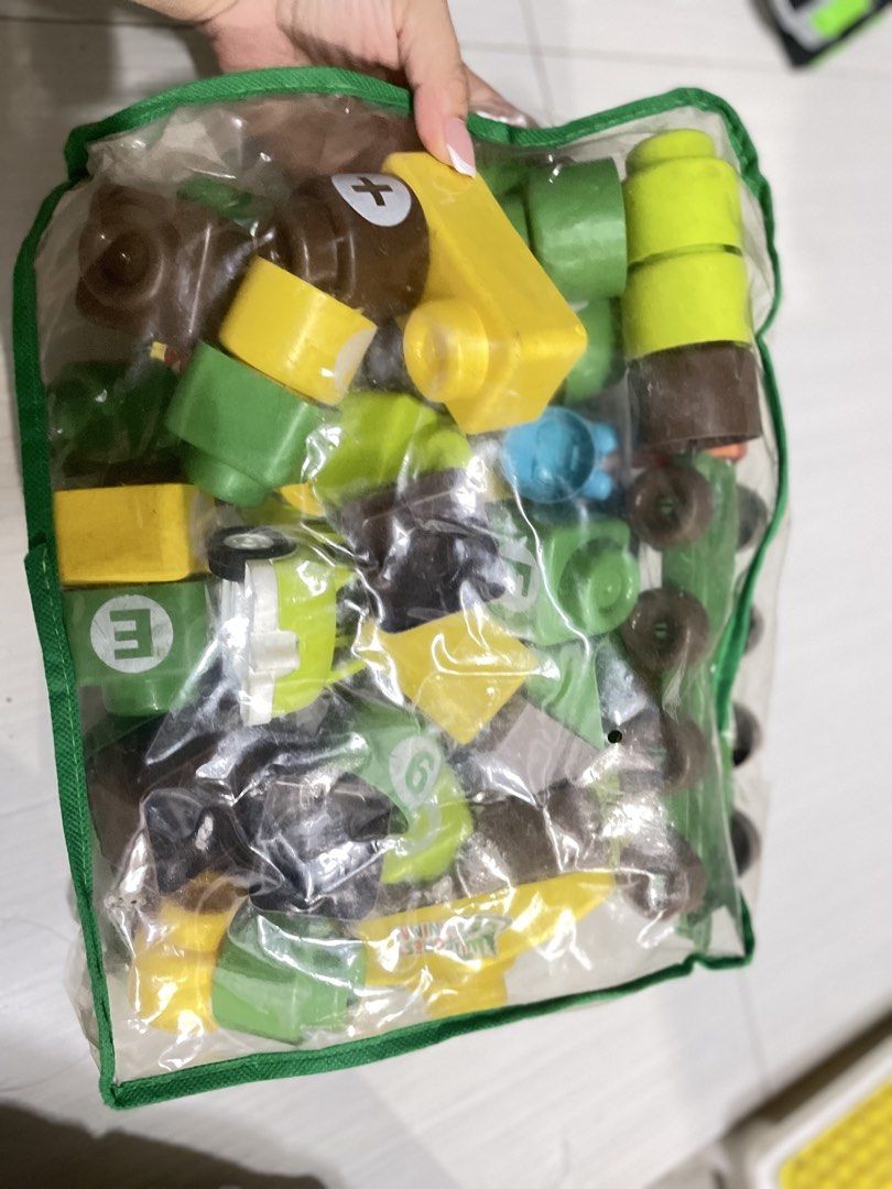 Mega Bloks Building Blocks Toy Set (Category: Lego & Building Sets) located in Quezon City. Submitted by prelovedclotheskimukays (Listing ID 1461266883, Image 3). Description: - Bag of Mega Bloks building blocks - Assorted colors (yellow, brown, green, orange) and shapes - Includes a green car and a grey base piece - Encourages creative play and building - Plenty of pieces for extended entertainment - Ideal for young builders.