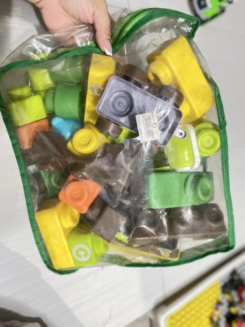 Mega Bloks Building Blocks Toy Set (Category: Lego & Building Sets) located in Quezon City. Submitted by prelovedclotheskimukays (Listing ID 1461266883, Image 2). Description: - Bag of Mega Bloks building blocks - Assorted colors (yellow, brown, green, orange) and shapes - Includes a green car and a grey base piece - Encourages creative play and building - Plenty of pieces for extended entertainment - Ideal for young builders.