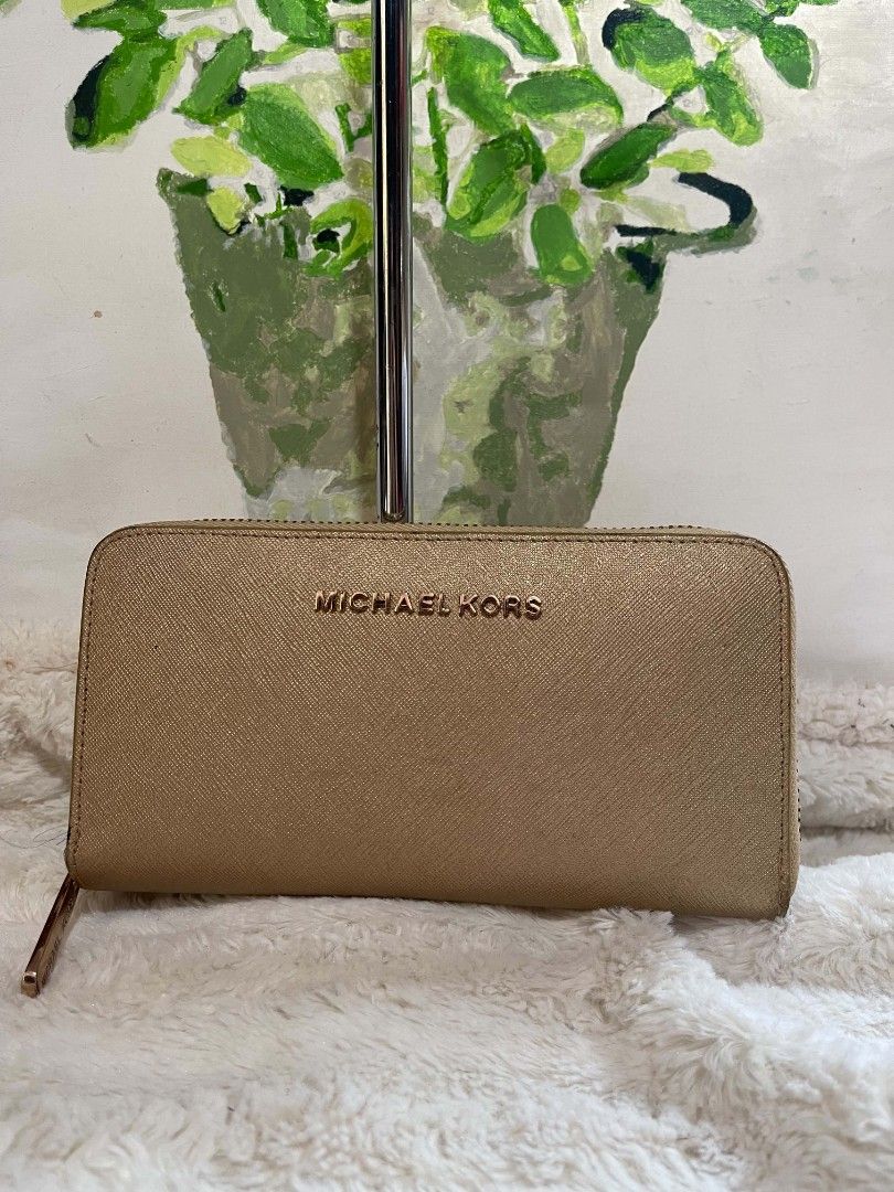 Michael Kors Gold Zip Around Wallet (Category: Wallets & Card holders) located in Naawan. Submitted by twilly.apparel2 (Listing ID 1461123796, Image 1). Description: - Gold Michael Kors Wallet - Secure Zip-Around Closure - Ample Card Slots for Organization - Interior Zippered Coin Pocket - Dimensions: Approximately 8 inches wide x 4 inches tall - Ideal for keeping your essentials neatly organized.