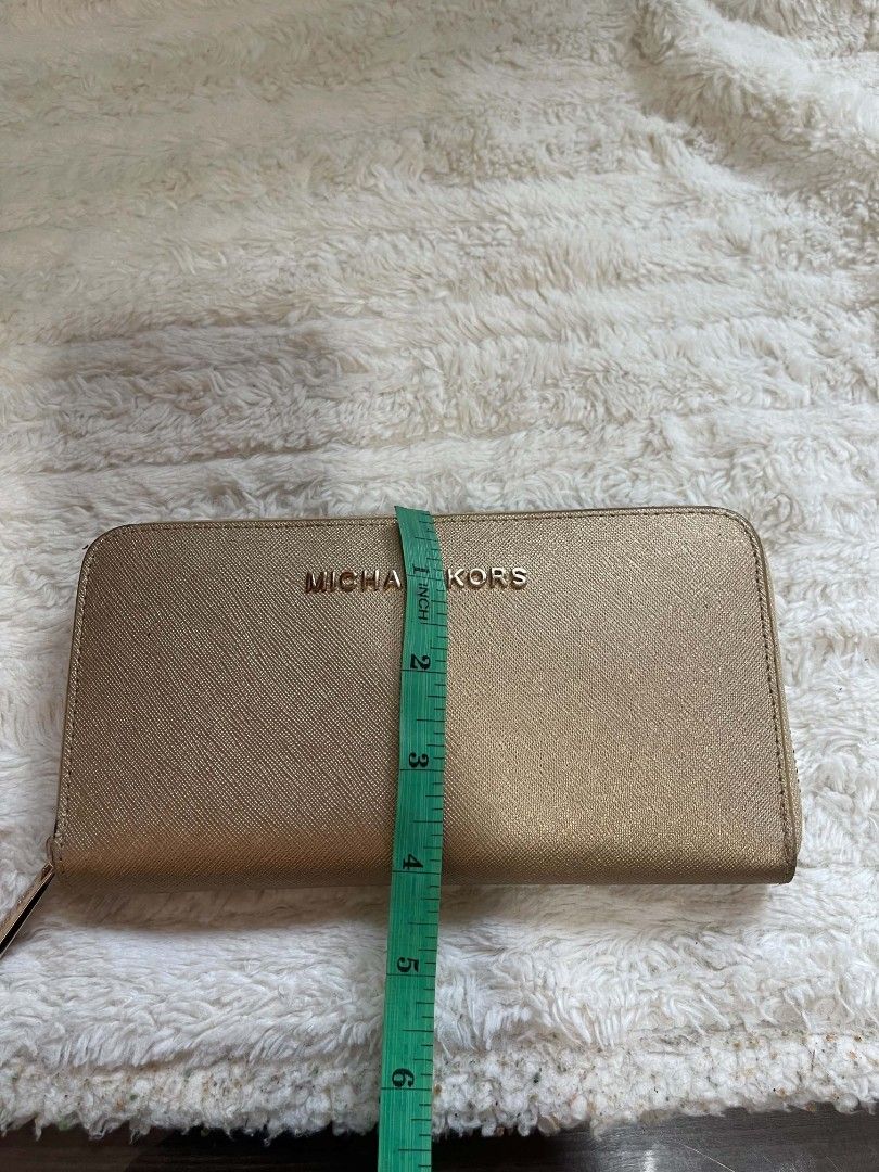 Michael Kors Gold Zip Around Wallet (Category: Wallets & Card holders) located in Naawan. Submitted by twilly.apparel2 (Listing ID 1461123796, Image 2). Description: - Gold Michael Kors Wallet - Secure Zip-Around Closure - Ample Card Slots for Organization - Interior Zippered Coin Pocket - Dimensions: Approximately 8 inches wide x 4 inches tall - Ideal for keeping your essentials neatly organized.