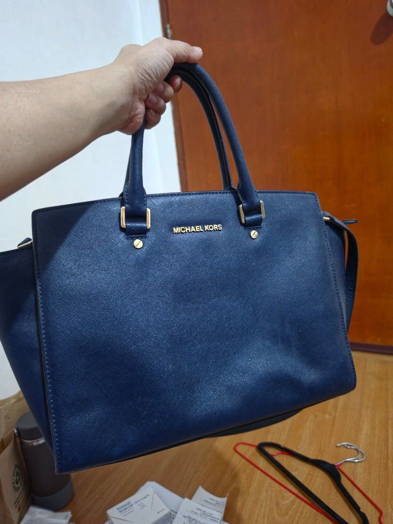 Michael Kors Navy Blue Leather Tote Bag (Category: Tote Bags) located in Taytay. Submitted by camsyron (Listing ID 1461147106, Image 1). Description: - Authentic Navy Blue Michael Kors Tote Bag - Genuine Saffiano Leather - Elegant Gold Hardware Details - Versatile: Top Handles & Detachable Shoulder Strap - Spacious Interior for Essentials - Impeccably Clean Inside and Out - Ideal for Work, School, or Everyday Carry.