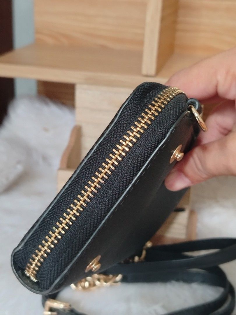 Michael Kors Zip Around Wallet on Chain (Category: Wallets & Card holders) located in Lucena. Submitted by gracious_chin0436 (Listing ID 1461185809, Image 3). Description: - Brand: Michael Kors - Color: Black - Material: Saffiano Leather - Hardware: Gold-tone with - Closure: Zip-around - Features: Detachable chain and leather strap - Versatile: Can be used as a clutch or crossbody bag - Interior: Plenty of space for cards and cash - Ideal for: Ev