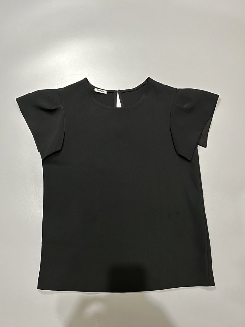 Miu Miu Black Flutter Sleeve Top (Category: Blouses) located in Manila. Submitted by jorgemabelin2001 (Listing ID 1461131500, Image 1). Description: - Brand: Miu Miu - Color: Black - Features: Cute flutter sleeves - Neckline: Round with keyhole back closure - Style: Simple, chic, versatile - Pair with: Skirts or trousers -Dimes 18.5x24.5.