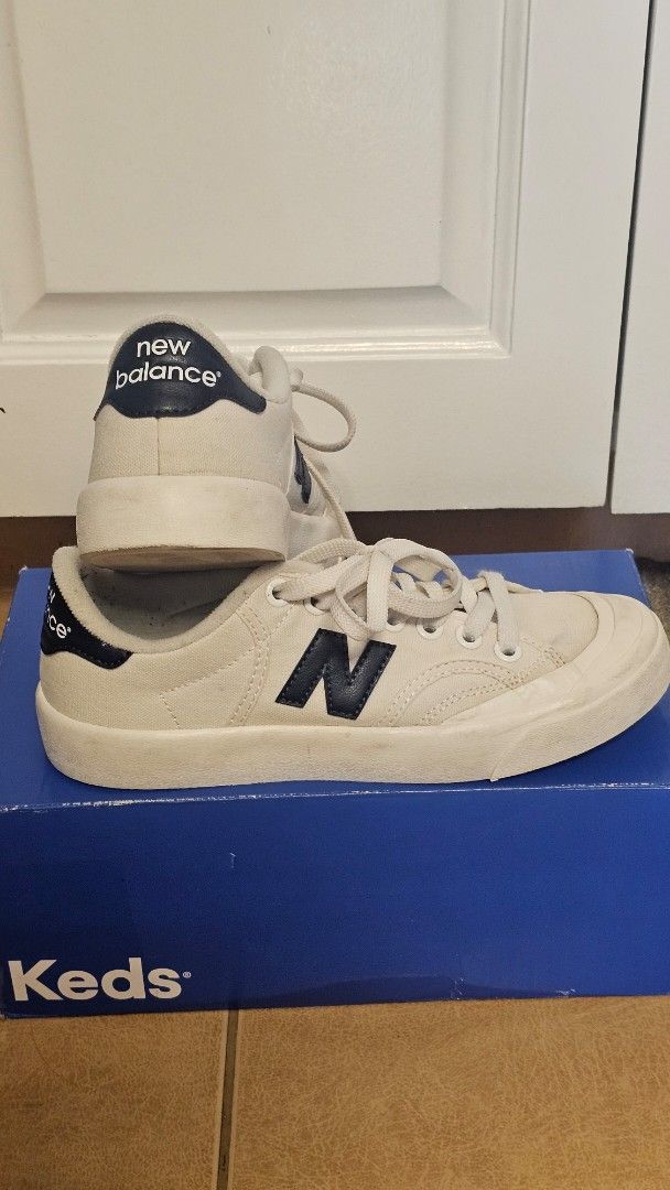 New Balance Canvas Sneakers (Category: Sneakers) located in Quezon City. Submitted by jollythrift (Listing ID 1461264636, Image 1). Description: - Brand: New Balance - Style: White canvas low-top sneakers - Features: Classic navy 'N' logo on the side, navy heel tab accents - Laces: White.
