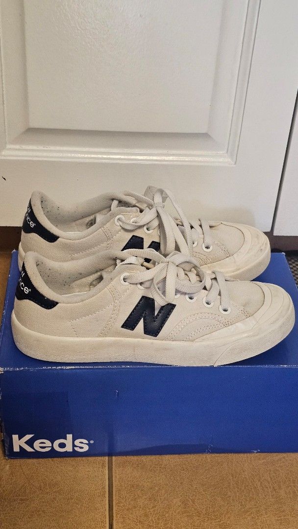 New Balance Canvas Sneakers (Category: Sneakers) located in Quezon City. Submitted by jollythrift (Listing ID 1461264636, Image 2). Description: - Brand: New Balance - Style: White canvas low-top sneakers - Features: Classic navy 'N' logo on the side, navy heel tab accents - Laces: White.