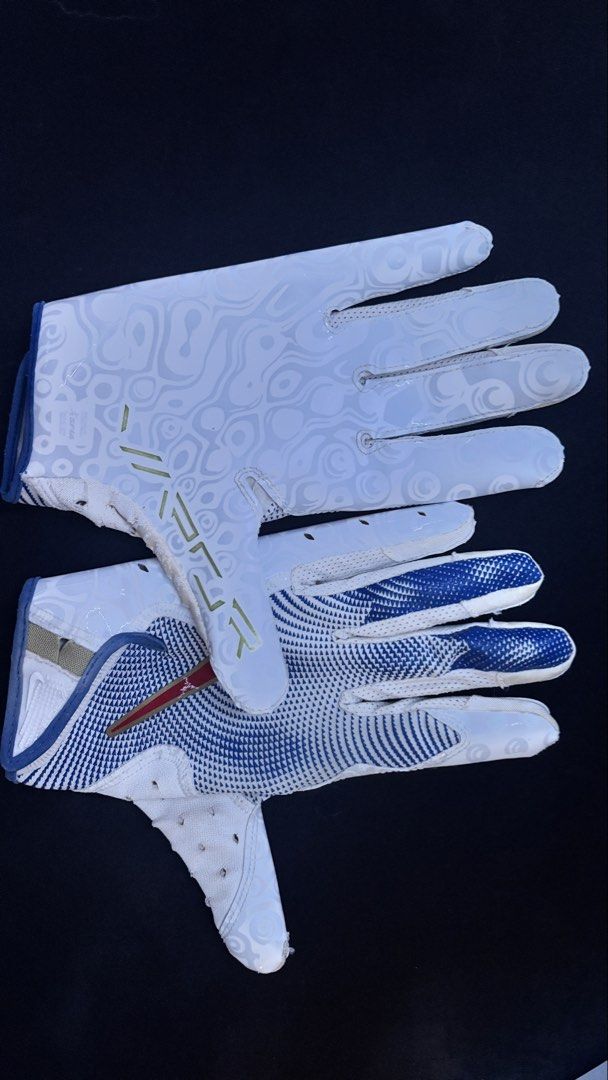 Nike Football Receiver Gloves (Category: Other Sports Equipment and Supplies) located in Cebu City. Submitted by kingkongma09919 (Listing ID 1461256204, Image 1). Description: - White and blue Nike football gloves - Unique swirling pattern on white areas - Blue textured grip on fingers and palm for enhanced control - Estimated size: Medium - Ideal for playing football or flag football.