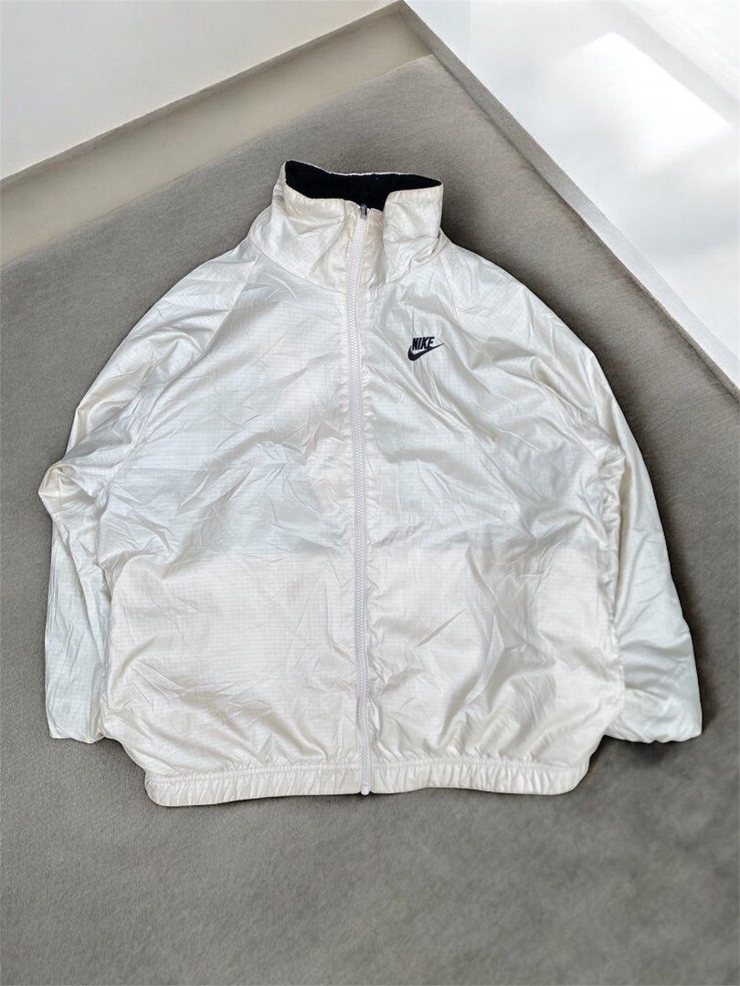Nike Reversible Fleece & Windbreaker Jacket (Category: Coats, Jackets and Outerwear) located in General Trias. Submitted by mangu_ukay (Listing ID 1461227166, Image 3). Description: - Super cool Nike reversible jacket - Side 1: Cozy black fleece with large white swoosh - Side 2: Lightweight white windbreaker with small Nike logo - Versatile for different weather conditions - Smooth zip closure - Ideal for casual wear.