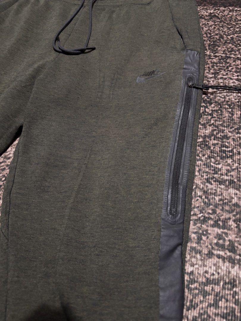 Nike Tech Fleece Joggers Olive Green Size L (Category: Joggers) located in Baguio. Submitted by zzlanuza34050 (Listing ID 1461125313, Image 2). Description: - Nike Tech Fleece Joggers - Color: Olive Green - Size: Large (L) - Signature Tech Fleece material for warmth and comfort - Convenient zippered side pocket - Adjustable drawstring waist for a personalized fit - Ideal for everyday casual wear or athletic activities 30*37.