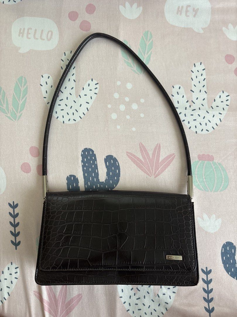 Nine West Croc Embossed Shoulder Bag (Category: Purses & Pouches) located in Calamba. Submitted by teriberry30 (Listing ID 1461171769, Image 1). Description: - Dark brown Nine West shoulder bag - Chic croc embossed texture all over - Spacious main compartment - Interior zip pocket for essentials - Secure magnetic snap closure - Timeless and classic design - Ideal for daily use.