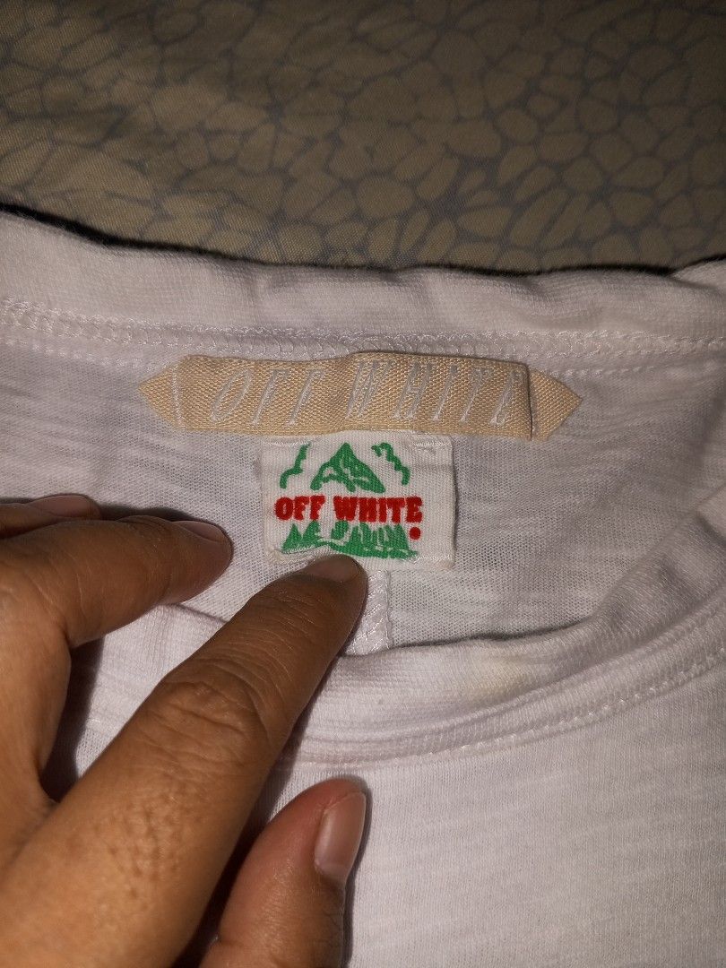 Off-White White T-Shirt Diagonal Stripe Graphic (Category: Tshirts & Polo Shirts ) located in Magalang. Submitted by zeiansoria64090 (Listing ID 1461235818, Image 3). Description: - Off-White t-shirt -L-xl - Features iconic diagonal stripe graphic on the back - 'WHITE' text prominently displayed on front and back - Perfect for everyday casual wear - Tag shows Off-White branding.